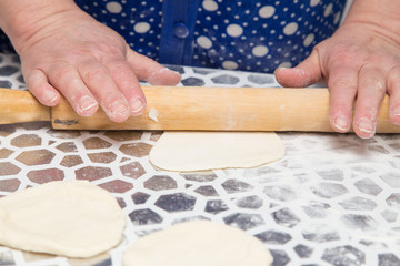 sheeting the dough with a rolling pin in the kitchen