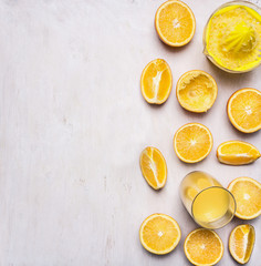preparation of orange juice squeezed fruit juicer on white wooden rustic background top view close up border ,place for text