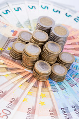 A pile of coins on a fan of bank notes