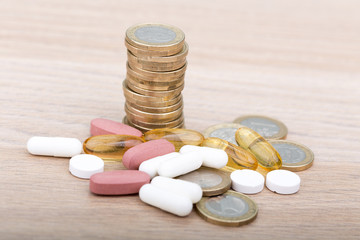Stack of coins between capsules and pills