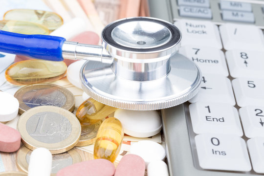 Stethoscope On A Pile Of Money And Pills With A Calculator On The Side