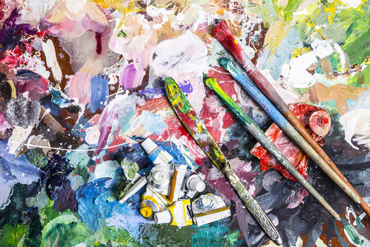 Palette of artist for mixing paints and a brush with a knife