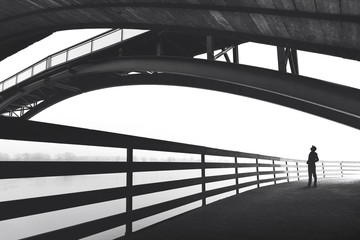 Man standing under bridge arch