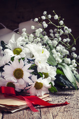Bundle of old letters tied with a scarlet ribbon with a bouquet