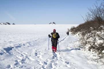 Men hiking in winter on a snow trail