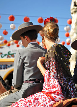 Pareja de j&oacute;venes a caballo en la feria de Sevilla, Esp&ntilde;a