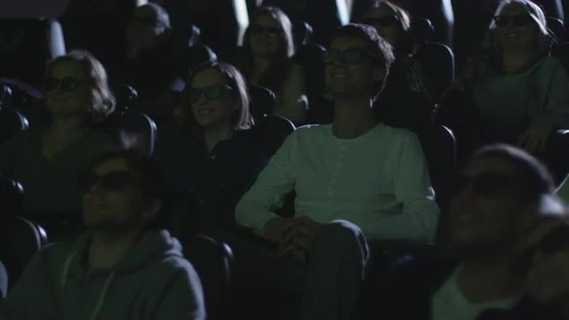 People are having fun while watching 5d film screening in cinema.  Shot on RED Cinema Camera.