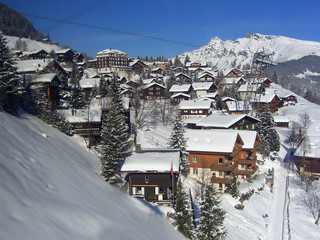 Quaint snowy village of wooden homes on Swiss mountain - landscape photo