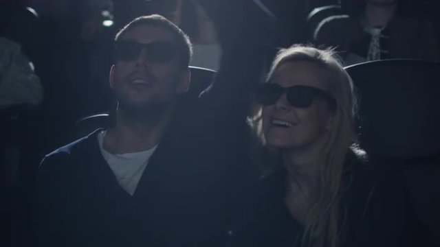 Couple embrace each other while having fun watching 5d film screening in cinema.  Shot on RED Cinema Camera.