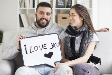 Young couple showing love message written on white board. I love you message. Valentines couple,shallow depth of filed
