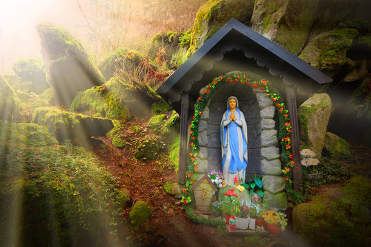 Our Lady of Lourdes (Virgin Mary) on place of wonders, wishing well in deep Bohemian forest (Konstantinovy Lazne) near Karlovy Vary, Czech Republic. Amazing European landmark. Warm filtered picture.