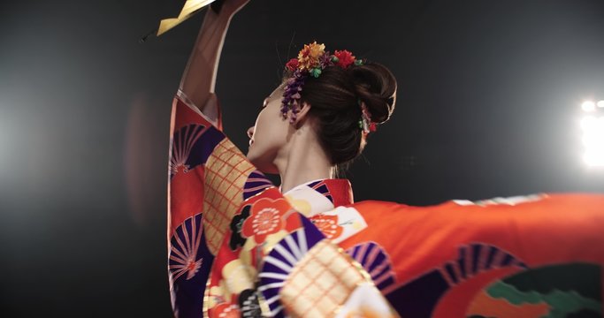 4K beautiful Japanese geisha dancing on stage and posing for the camera,the smoke in the background, slow motion