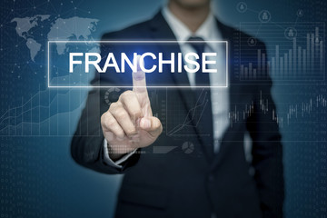 Businessman hand touching FRANCHISE button on virtual screen