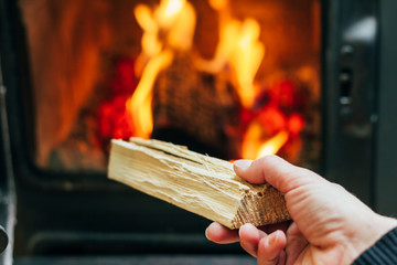 Woman Putting Logs In Fireplace