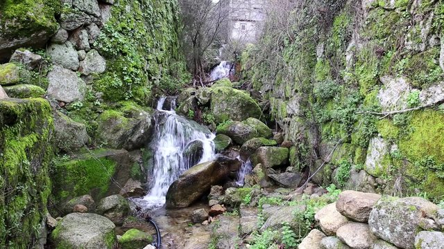 a stream through stones with moss in Castelo Novo, Fund&atilde;o, Portugal