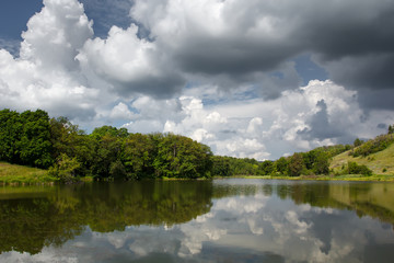 Fototapeta na wymiar Beautiful nature landscape. Trees reflected on water at summertime