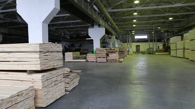 Warehouse timber plant. Boards on the shelves inside the hangar 