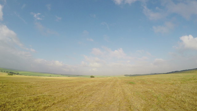 Panoraming the meadow to a blue sky and clouds