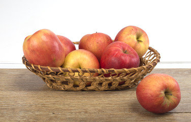 Naklejka na ściany i meble apples in a basket on a wooden background