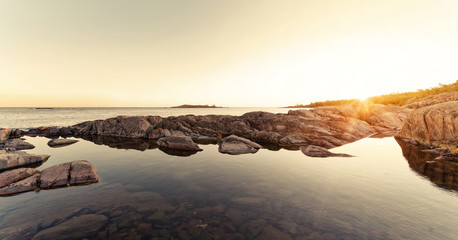 Sunrays over rocky coast during early morning © stefanholm