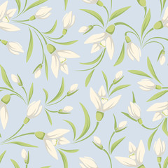 Vector seamless pattern with white snowdrop flowers and green leaves on a blue background.