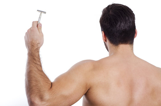 Closeup Of Muscular Man Holding Razor, Back Turned, Man Shaving Concept