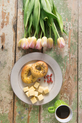 Breakfast, cup of coffee and flower arranged on a old rustic wooden table