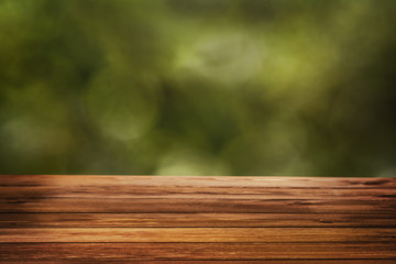 Natural bokeh background with wooden table surface and green copy space in the distance. Copy space for concept or advertising.