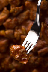 a piece of meat goulash, impaled on a fork