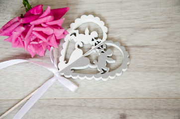 pink rose and a wooden heart with angels