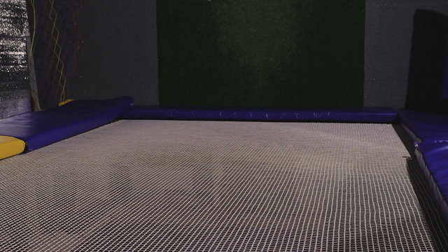 A young woman in a T-shirt. Jumping on a trampoline is ridiculous. 