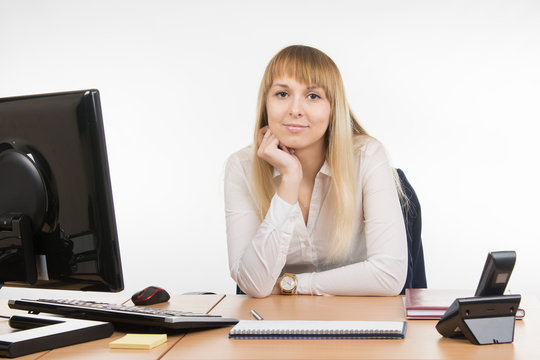 Business woman sitting at a desk in the office and looking at the frame