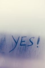 Agreement sign of Yes written on foggy window background. 