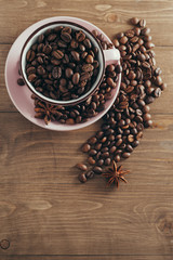 Cup of coffee beans on a wooden background
