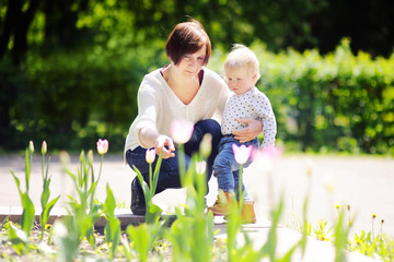 Middle aged woman and her little grandson in sunny park