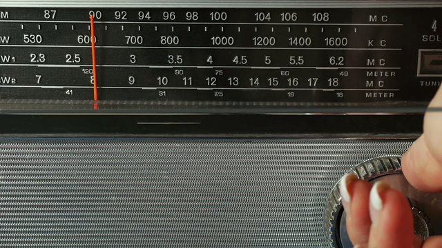Old Radio Dial Being Tuned By Female Hand