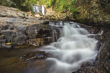 Naklejka na ściany i meble Tropical waterfall in deep forest of thailand 