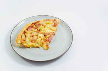 Slice of pineapple and ham pizzas on the plate