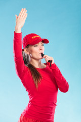 Lifeguard woman in cap on duty blowing whistle.