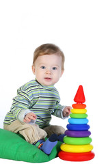 Obraz premium Caucasian baby boy playing colorful toys on a white background