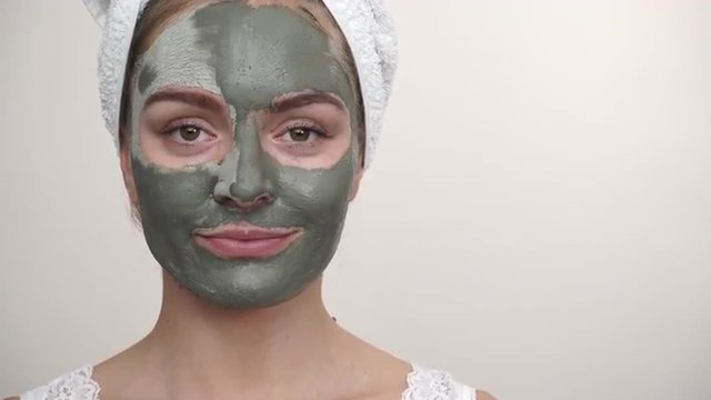Woman with green clay mud mask on face 4K