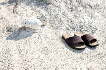 bamboo shoes on white sand background