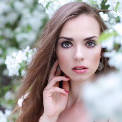 Close-up portrait of young beautiful woman in spring blossom tre