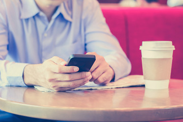 A man using smart phone in coffee shop