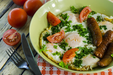 Breakfast - scrambled eggs with tomatoes and greens