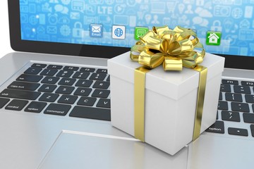 Gift box with ribbon on laptop keyboard