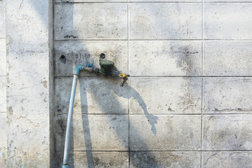 old faucet on old peeling paint brick wall grunge and dirty