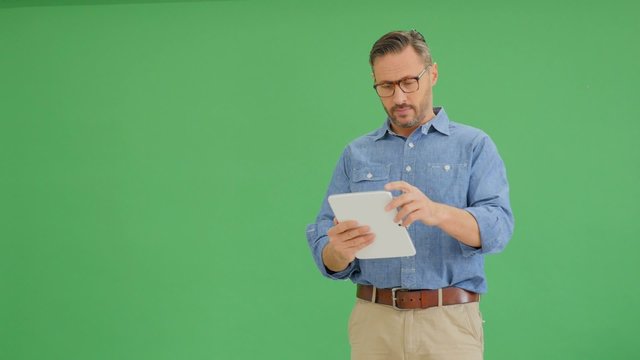 Middle-aged man making presentation and using tablet