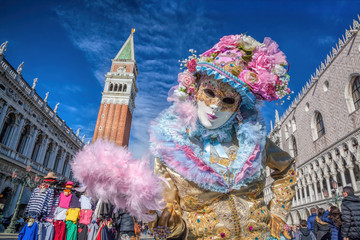 Karnevalsmaske gegen Glockenturm auf dem Markusplatz in Venedig