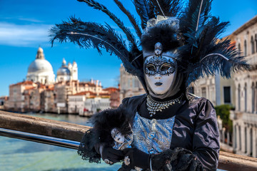 Fototapeta na wymiar Beautiful carnival masks against Salute cathedral in Venice, Italy